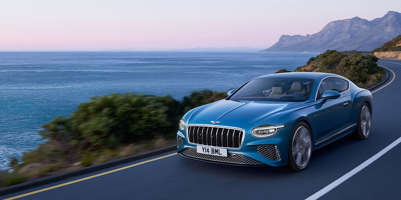 Bentley Abu Dhabi New Bentley Continental GT Azure coupe in Light Windsor blue paint with 22 inch Azure wheels and chrome grill, driving dynamically by the se